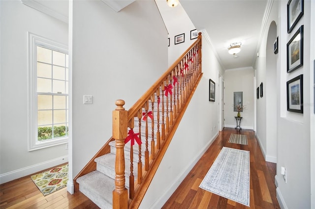 interior space with dark wood-type flooring, ornamental molding, and baseboards