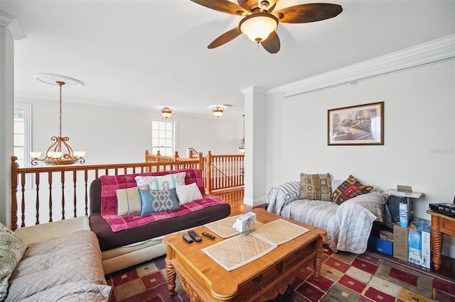 living room with crown molding and ceiling fan with notable chandelier