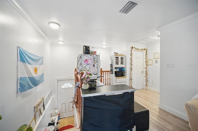 kitchen featuring ornamental molding, visible vents, light wood-style floors, and baseboards