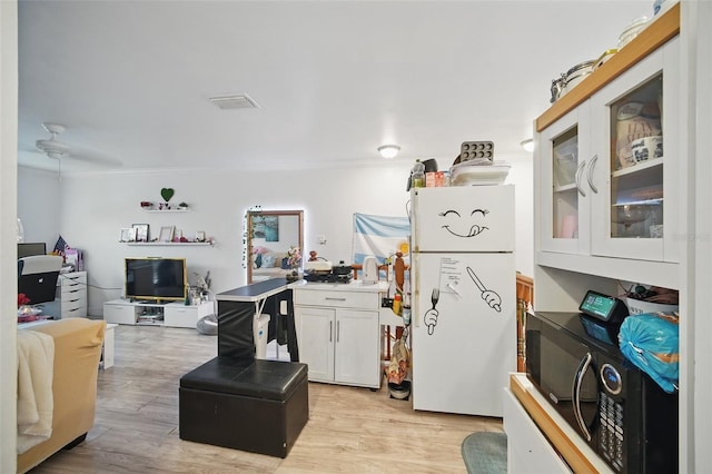 kitchen with light wood-style flooring, visible vents, white cabinets, open floor plan, and glass insert cabinets