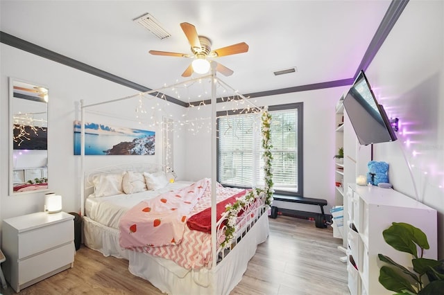 bedroom featuring ornamental molding, visible vents, and light wood-style floors