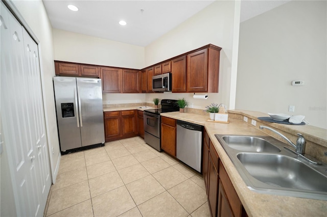 kitchen featuring recessed lighting, light countertops, appliances with stainless steel finishes, light tile patterned flooring, and a sink