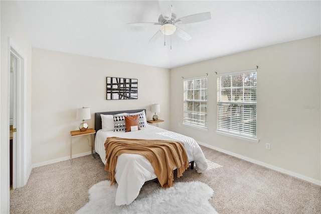 carpeted bedroom with ceiling fan and baseboards