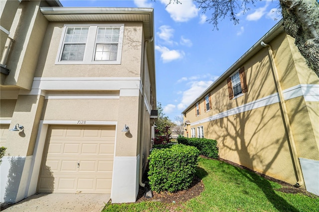 view of property exterior featuring an attached garage and stucco siding