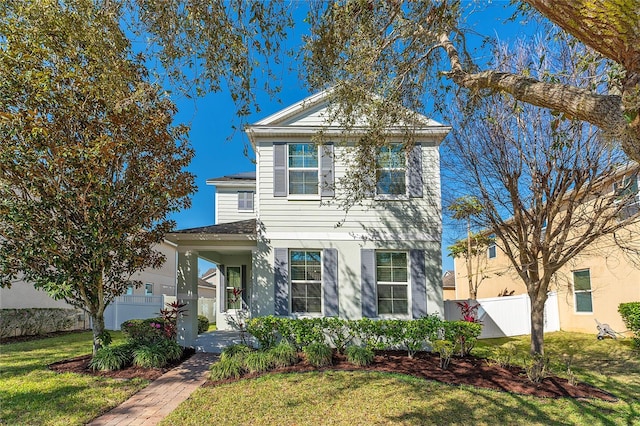 traditional-style home with a porch, fence, and a front lawn