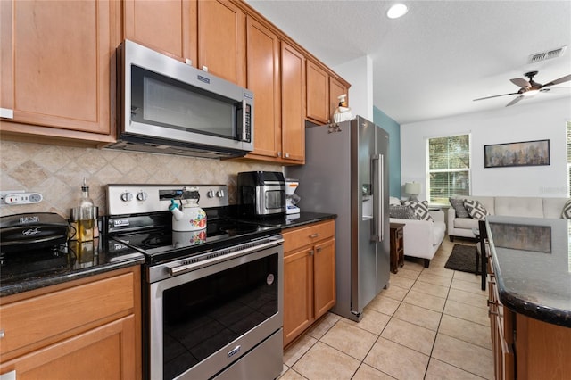 kitchen featuring light tile patterned floors, tasteful backsplash, visible vents, appliances with stainless steel finishes, and open floor plan