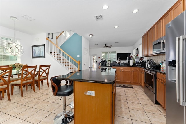 kitchen with pendant lighting, light tile patterned floors, visible vents, appliances with stainless steel finishes, and a peninsula