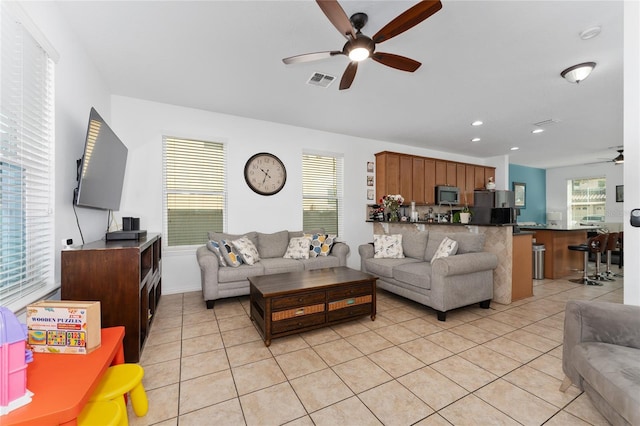 living room with a ceiling fan, recessed lighting, visible vents, and light tile patterned floors