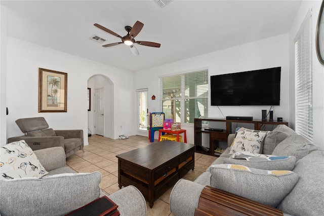 living room with visible vents, arched walkways, a ceiling fan, and light tile patterned flooring