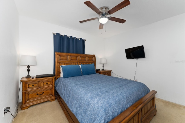 bedroom with a ceiling fan, light carpet, and baseboards