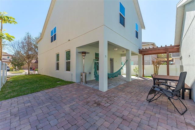 back of property with a yard, a patio area, fence, and stucco siding