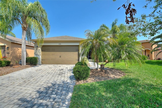 view of front of house featuring stucco siding, an attached garage, decorative driveway, and a front yard