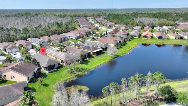 aerial view with a view of trees, a residential view, and a water view