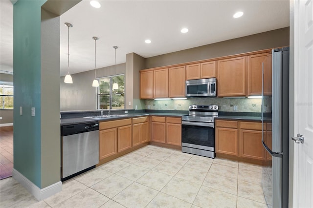 kitchen featuring dark countertops, backsplash, stainless steel appliances, and a sink