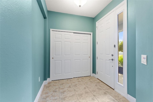 foyer with light tile patterned floors and baseboards