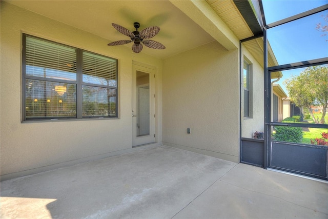 unfurnished sunroom with a ceiling fan