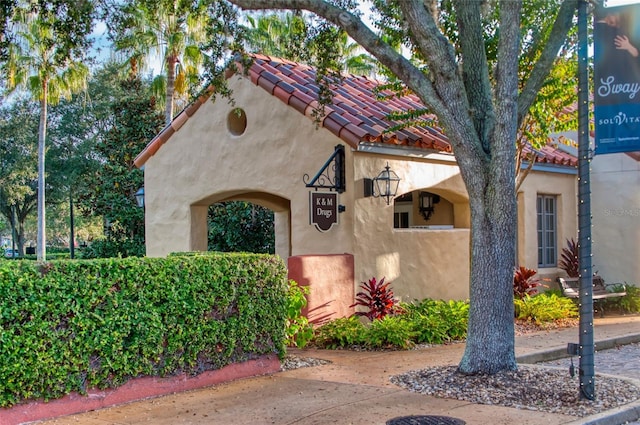 view of front facade with a tiled roof and stucco siding