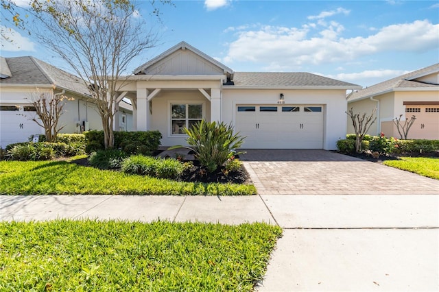 view of front of property featuring a garage, decorative driveway, and stucco siding