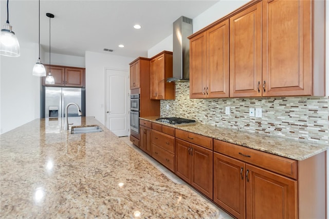 kitchen with light stone counters, stainless steel appliances, a sink, visible vents, and wall chimney range hood