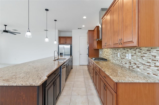 kitchen featuring appliances with stainless steel finishes, brown cabinets, a sink, and tasteful backsplash