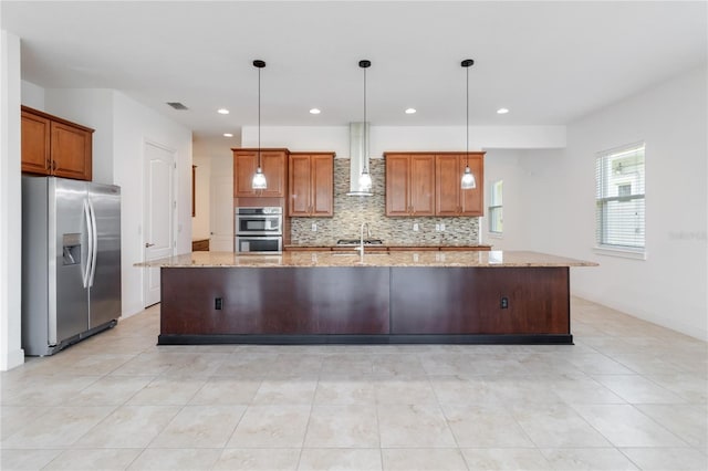 kitchen featuring visible vents, decorative backsplash, wall chimney exhaust hood, brown cabinets, and stainless steel appliances