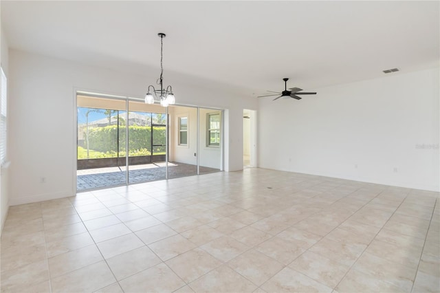 spare room featuring light tile patterned floors, visible vents, and ceiling fan with notable chandelier