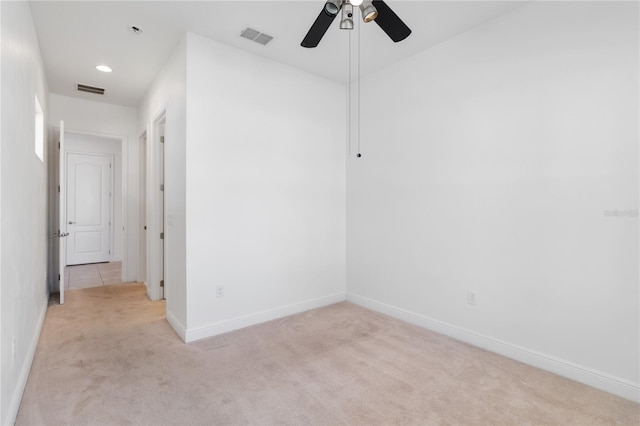 empty room featuring baseboards, visible vents, and light colored carpet