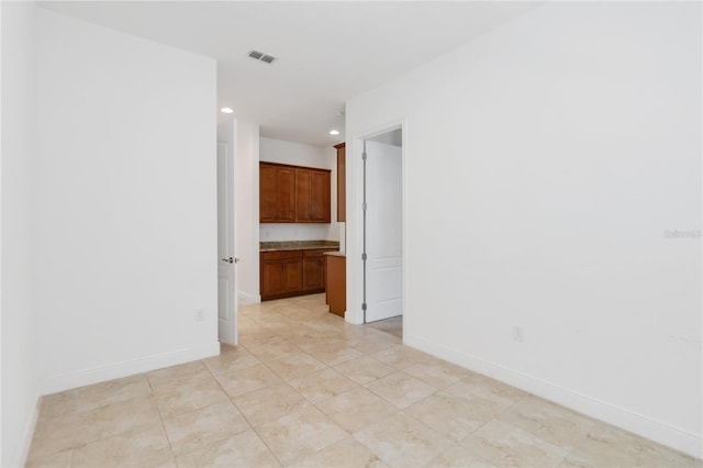 spare room featuring recessed lighting, visible vents, and baseboards