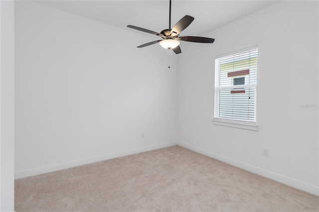 unfurnished room featuring a ceiling fan, light colored carpet, and baseboards