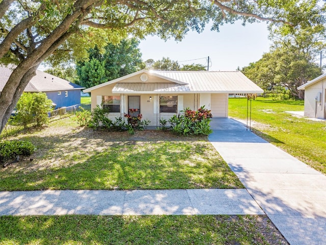 ranch-style house featuring a front yard, metal roof, an attached carport, and fence