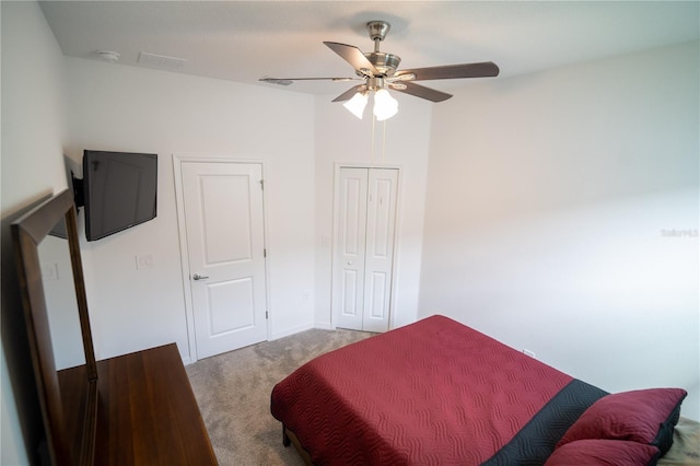 carpeted bedroom featuring ceiling fan and a closet