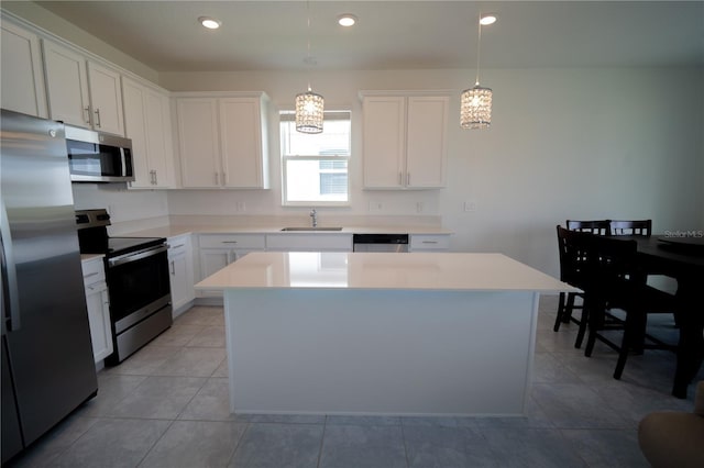 kitchen featuring appliances with stainless steel finishes, a kitchen island, a sink, and white cabinets