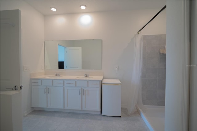 bathroom featuring tiled shower, a sink, and tile patterned floors