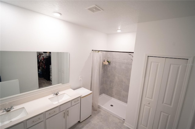 bathroom featuring a stall shower, a closet, visible vents, and a sink