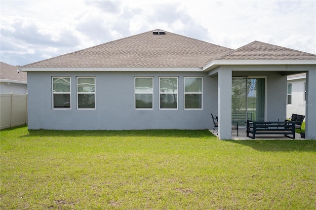 back of property with a shingled roof, a patio, fence, a yard, and stucco siding