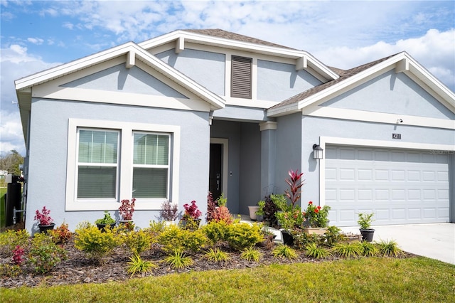 view of front of house featuring an attached garage, driveway, and stucco siding