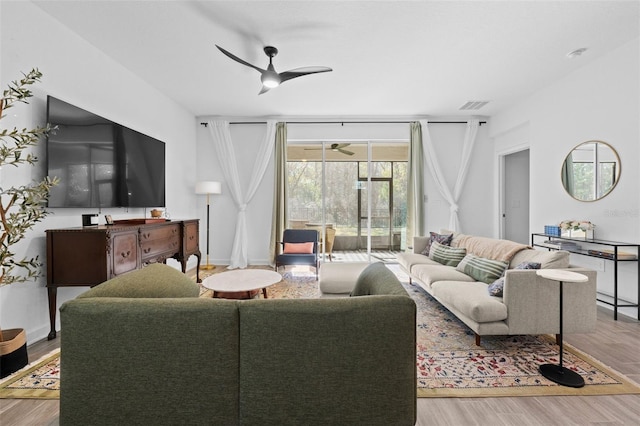 living room with a ceiling fan, baseboards, visible vents, and wood finished floors