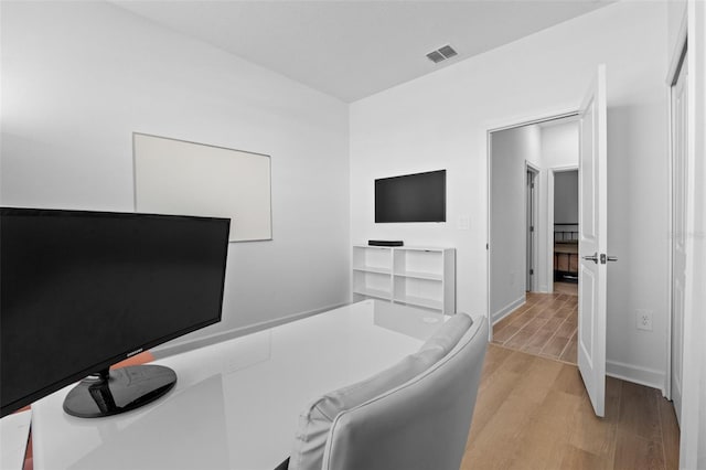 home office featuring baseboards, visible vents, and light wood-style floors