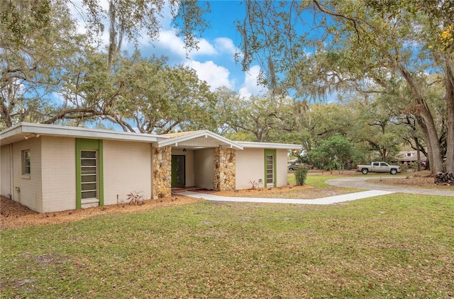 mid-century modern home with a front lawn and brick siding