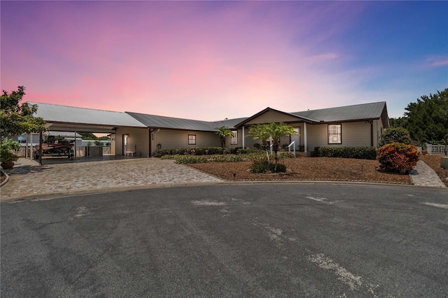 view of front of house with a carport, metal roof, and decorative driveway