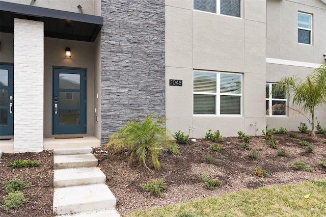 entrance to property featuring stucco siding