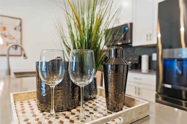 room details featuring white cabinets and refrigerator with ice dispenser