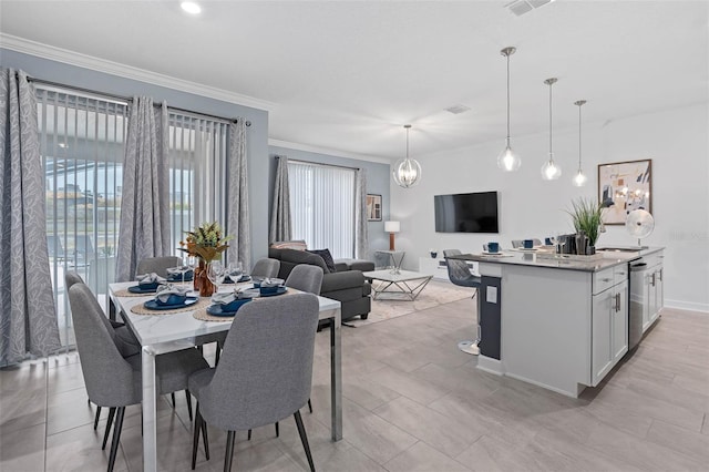 dining room with a chandelier, visible vents, crown molding, and baseboards