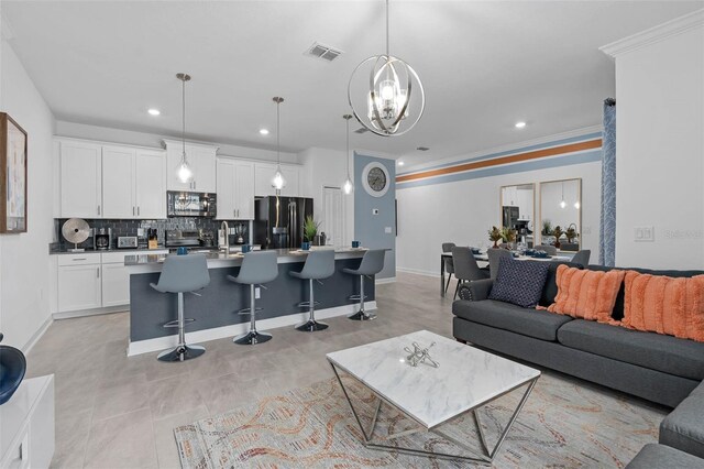 living room featuring visible vents, a notable chandelier, recessed lighting, crown molding, and baseboards