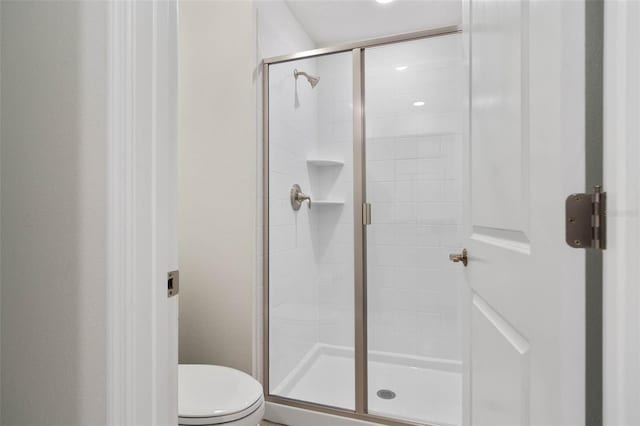 bathroom with toilet and a shower stall