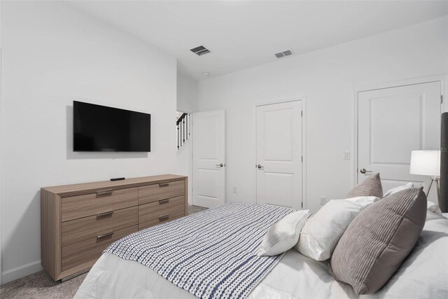 bedroom with visible vents, baseboards, and light colored carpet