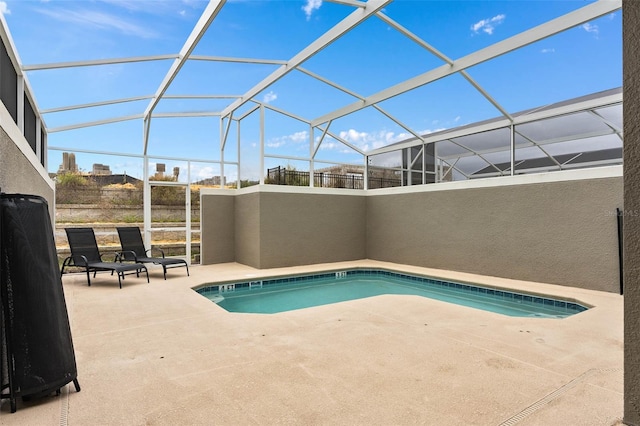 view of swimming pool featuring glass enclosure and a patio area