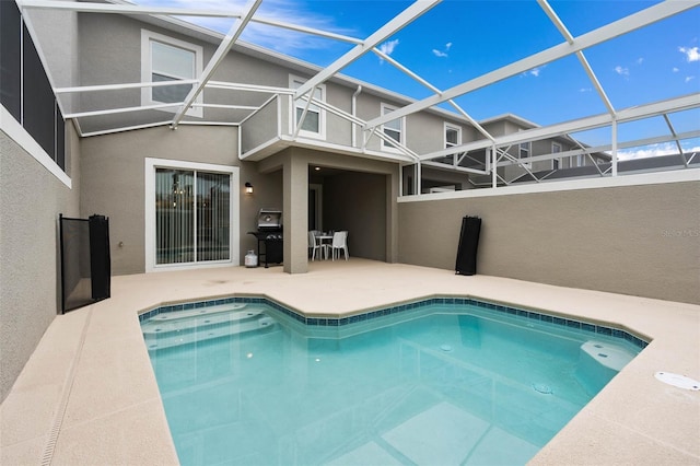 pool with a patio area, grilling area, and glass enclosure