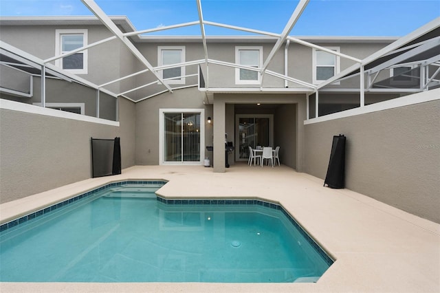 outdoor pool with a patio area and glass enclosure