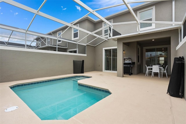 pool with a patio area and glass enclosure